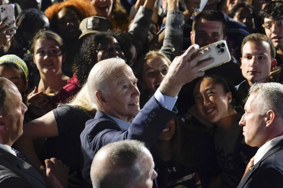 President Joe Biden takes a selfie with the crowd at a campaign event for New York Governor Kathy Hochul.