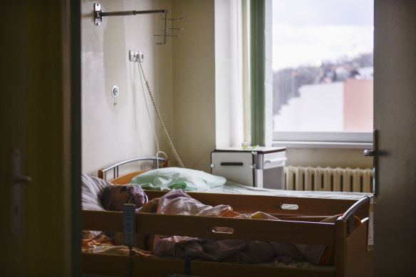 A patient suffering from COVID-19 lays in a bed at a general ward that has been converted to a COVID ward at the hospital in Bochnia, Poland.