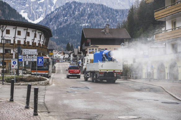 A truck equipped with a snow cannon fed with diluted hydrogen peroxide sanitises the streets in Selva di Val Gardena, Northern Italy, on Thursday.