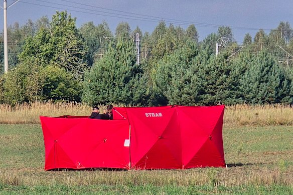 Firefighters work to recover remnants of a drone shot down near Czosnowka in eastern Poland.