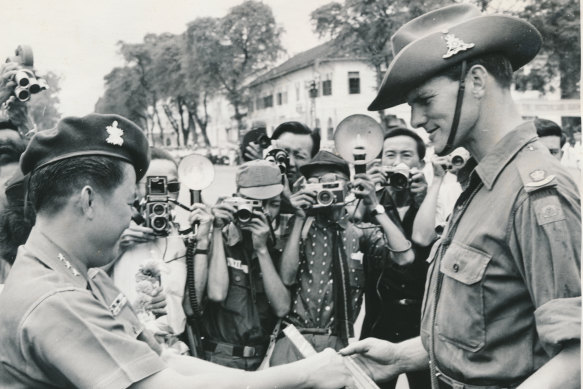 Major Peter Tedder, commander of the 105th Field Battery, is presented with a silver-mounted cane by Vietnamese Major General Tran Ngoo Tam.