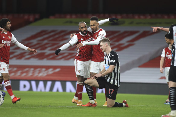 Pierre-Emerick Aubameyang celebrates with teammates after scoring Arsenal's third goal.