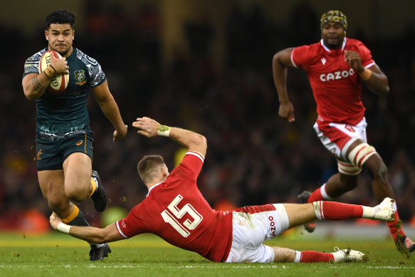 Wallabies centre Hunter Paisami skips past the tackle of Wales player Liam Williams .