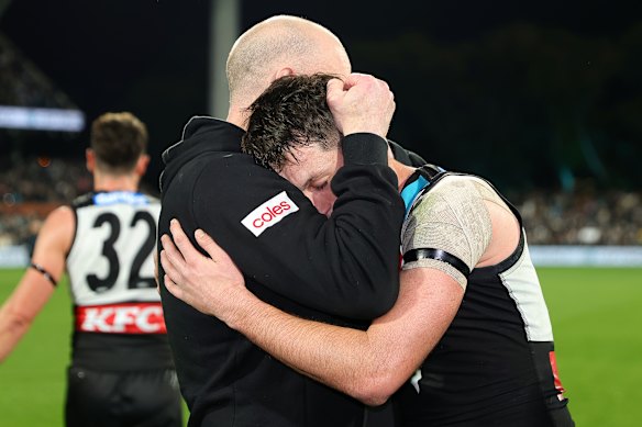 Zak Butters hugs Hinkley after his last game as coach.