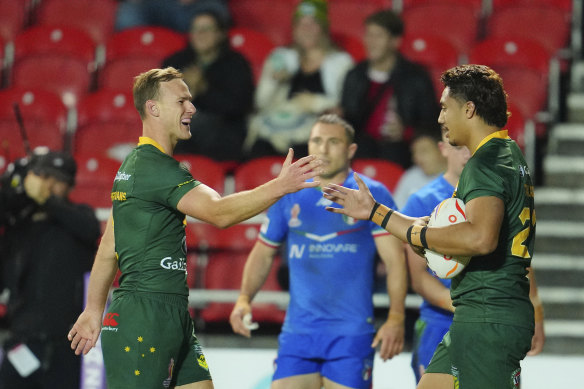 Daly Cherry-Evans and Murray Taulagi celebrate one of 12 Australian tries