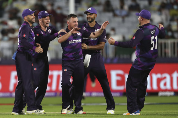 Greaves celebrates a wicket with teammates.