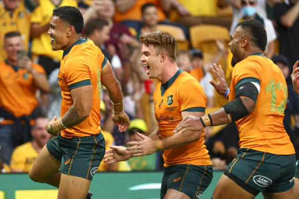 Australia’s Len Ikitau, left, is congratulated by teammates after scoring his first Test try.