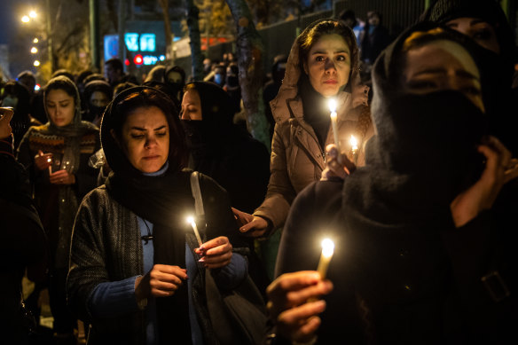 Demonstrators hold candles during a vigil for those who died in the shooting down of a Ukrainian Airlines plane.