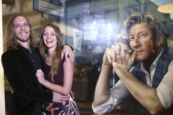 Roderick MacKay, left, with his wife Tessa and her portrait of the actor David Wenham, winner of the 2019 Archibald Packing Room Prize. Wenham also stars in MacKay's film. 