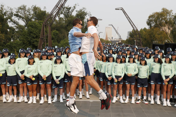 Bob and Mike Bryan bust out their trademark chest-bump ahead of the 360-strong Australian Open ballkids contingent.