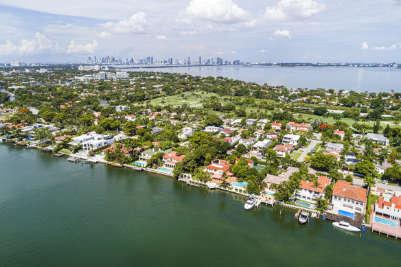 Miami Beach, Florida, Indian Creek La Gorce Island Country Club, waterfront mansions, estates homes and city skyline.