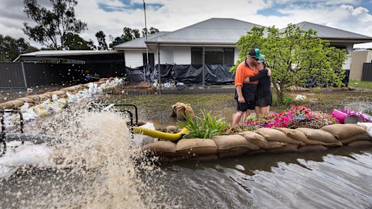 Kim Hay and her son Trent Wilson had to put up a new wall of sandbags after a breach in the early hours of the morning.