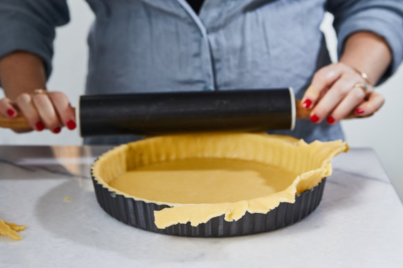 Cut off the excess pastry by running a rolling pin over the tart tin.