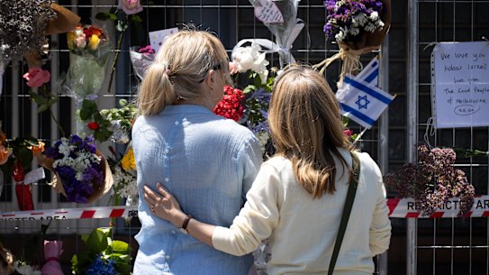People lay flowers at the Adass Israel synagogue in Ripponlea on Sunday.