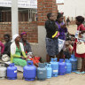 People wait in a queue for cooking gas at a garage in Harare on Wednesday.
