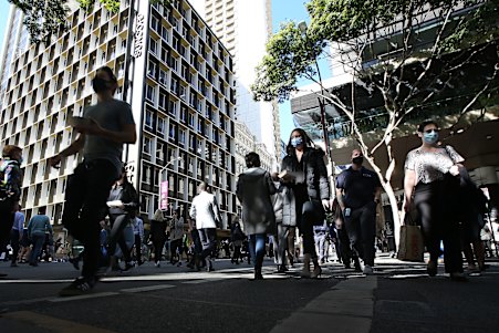 BRISBANE, AUSTRALIA - JULY 13: People walk through the CBD on July 13, 2021 in Brisbane, Australia. Queensland has recorded two new local COVID-19 cases overnight, but as the people were in home quarantine and are linked to known cases, premier Annastacia Palaszczuk has confirmed the planned easing of coronavirus restrictions will go ahead at the end of the week. Restrictions in Queensland will ease from 6am, Friday 16 July, with residents allowed to leave home for any reason self-isolating as a close contact or awaiting test results. Face masks will no longer be required except for at airports and on planes. Shops, restaurants, cafes, cinemas, gyms, beauty services and other businesses can operate subject to density limits and COVID-safe rules, while dancing will also be permitted. Indoor gatherings will increase to 100 people while there is no limit on the number of people for outdoor weddings or funerals. (Photo by Jono Searle/Getty Images)