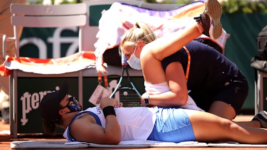 Ash Barty receives medical treatment for a leg injury in her first-round match against Bernarda Pera.