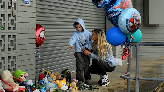 Tamika Pinner consoles her six-year-old grandson, Talakai Hura, at a vigil in front of the Wyong Memorial Olympic Pool.
