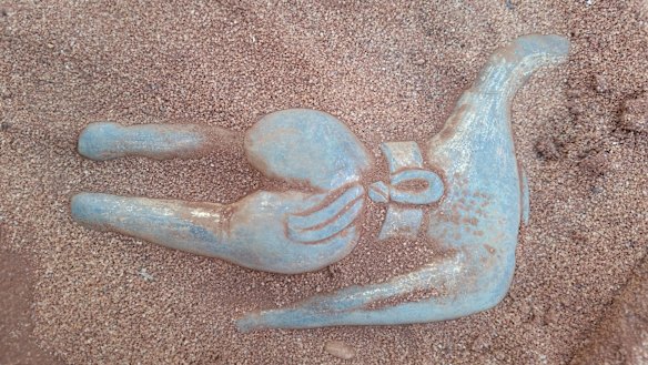 They brushed away the sand before gently dislodging the statue from its resting place. 