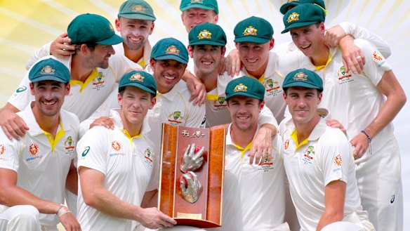 Long wait: Australia's captain Tim Paine holds the trophy as he poses with teammates after they finally broke through for a series victory.
