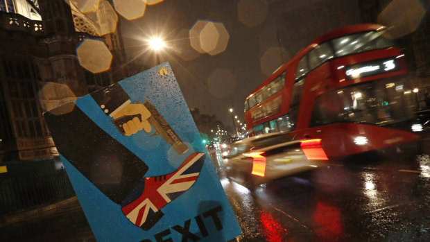 Vehicles drive past an anti-Brexit placard near the British Parliament on Tuesday.