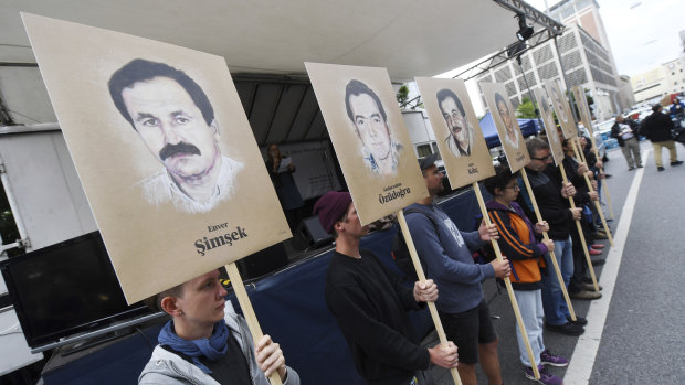 Demonstrators hold signs with people killed by the NSU outside the court in Munich.