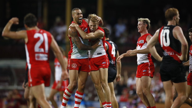 Callum Mills of the Swans celebrates a goal with Lance Franklin.