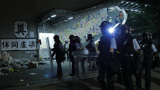 Police officers in anti-riot gear clear protesters from the Legislative Council in Hong Kong.
