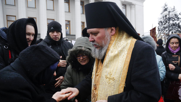 An Orthodox believer kisses the hand of a priest of the Ukrainian Orthodox Church of Moscow Patriarchy during a protest against the creation of a Ukrainian independent church, in front of the parliament building in Kiev, Ukraine, last week. 