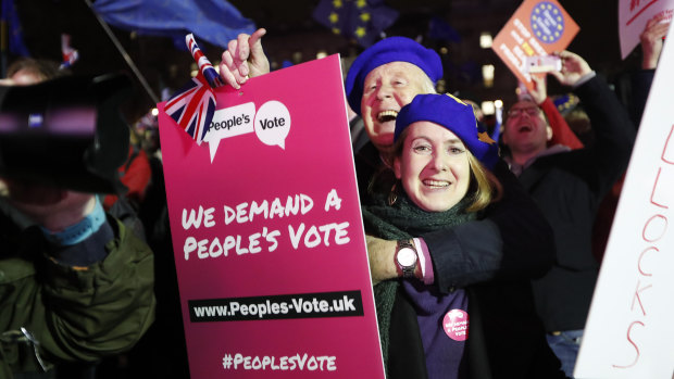 Anti-Brexit demonstrators react after the results of the vote on British Prime Minister Theresa May's Brexit deal were announced in Parliament square in London.