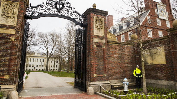 A police officer stands by an entrance to Harvard Yard on the closed Harvard University campus in Cambridge, Massachusetts. The university is returning unspent funds donated by disgraced financier Jeffrey Epstein.