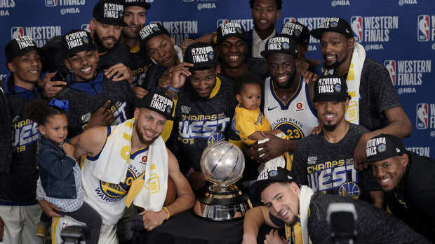 The Golden State Warriors pose with their trophy.