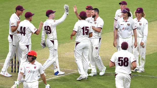 Queensland bowler Michael Neser (centre) celebrates dismissing South Australian batsman Harry Nielsen (left) for nought on day 1 of the Round 9 Sheffield Shield match at The Gabba on Monday.