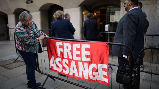 A supporter of the Wikileaks founder Julian Assange hangs a banner outside the Old Bailey on September 14, 2020 in London.
