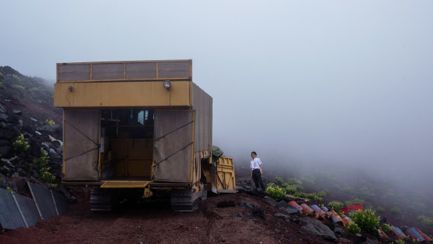 The tractor drops off supplies at the last station hut before the summit on Mount Fuji.