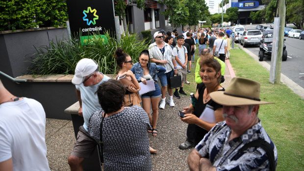 Queues stretch down the street outside a Centrelink office on the Gold Coast. 