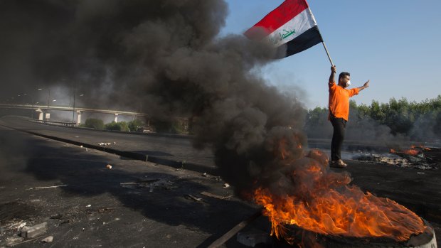 Anti-government protesters light fires to close streets and bridges during protests in Basra, Iraq.