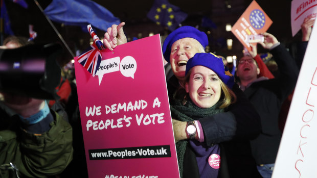 Anti-Brexit demonstrators react after the results of the vote on British Prime Minister Theresa May's Brexit deal were announced in Parliament Square in London.