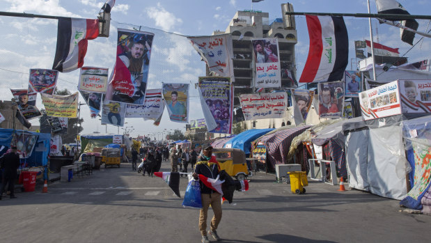 A street vendor sells Iraqi flags to anti-government protesters during ongoing protests in Tahrir square, Baghdad, on Christmas Day.