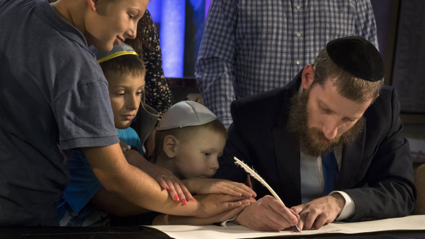 Members of Lithuania's Jewish community write in a new Torah dedicated to unity and goodness, commemorate death of family members and remember all who have died or been tortured in the Holocaust.