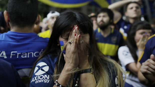 A Boca fan reacts to the loss as she watches on television in Buenos Aires.