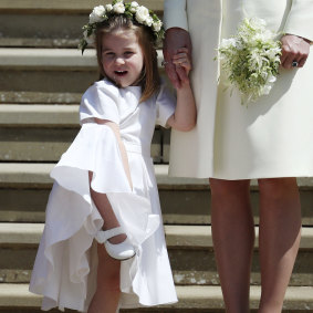 Princess Charlotte looks at Meghan Markle and Britain's Prince Harry.