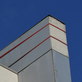 A panel of the cladding fell off the facade of the building, and is now being held together by ratchet straps. 