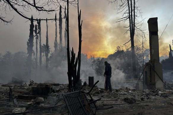 A resident hoses down hot spots in a fire-ravaged property in the Pacific Palisades neighbourhood of Los Angeles.