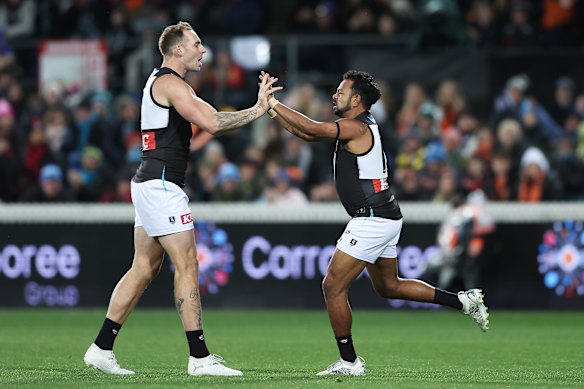 Willie Rioli celebrates with Jeremy Finlayson after kicking a goal.