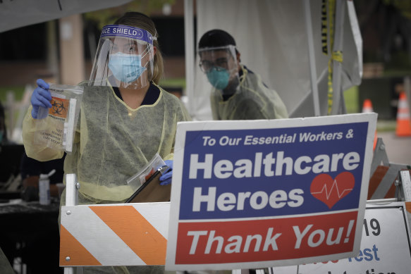 A worker hands out testing kits at a mobile coronavirus testing site in Los Angeles this week.