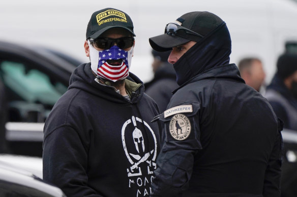 People wearing hats and patches indicating they are part of the Oath Keepers attend a rally in support of Donald Trump on January 5.