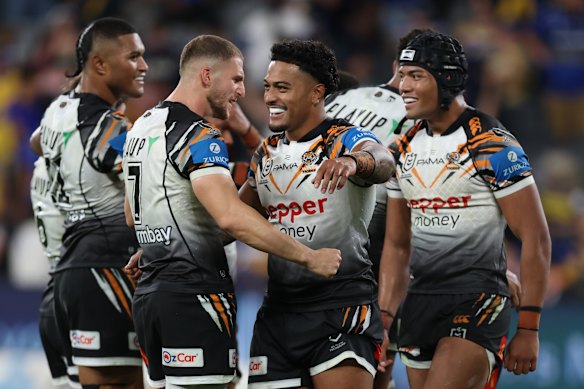 Tigers players celebrate after clinching a golden-point victory over Parramatta.