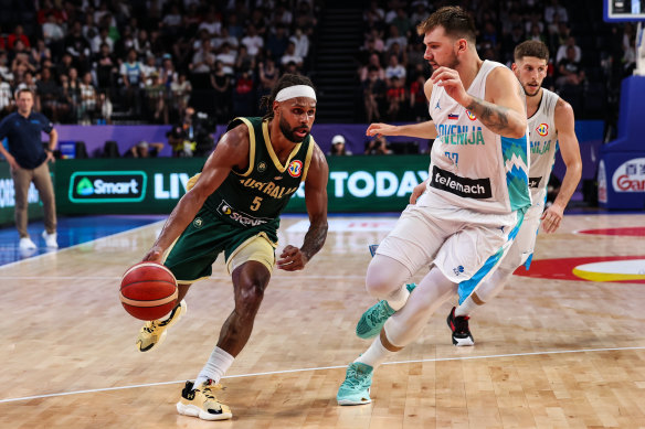 Patty Mills drives to the basket against Luka Doncic of Slovenia.
