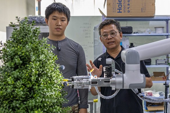 BlueX Robotics founder Chen Zhijun (right) demonstrates his company’s blueberry picking machine at the start-up’s office in Shenzhen.